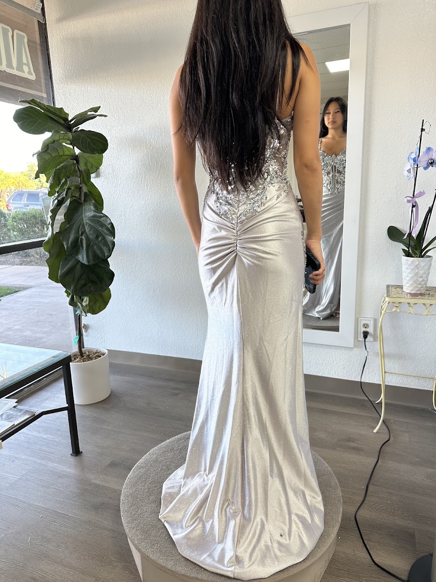 Fitted ivory satin gown with a sculpted back in the fitting room
